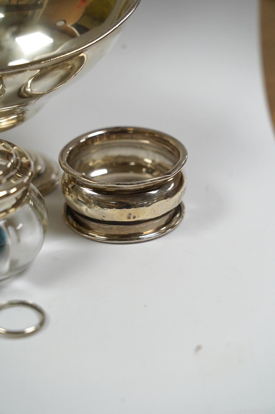 An Edwardian silver boat shaped sugar basket, by Thomas Bradbury & Sons, London, 1905, 13.9cm, together with two silver napkin rings, mounted glass hair tidy and a sterling pomander. Condition - poor to fair